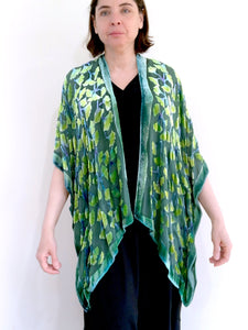 modeling green gingko leaf devoré or burnout velvet kimono jacket that is hand painted. Worn over back dress.