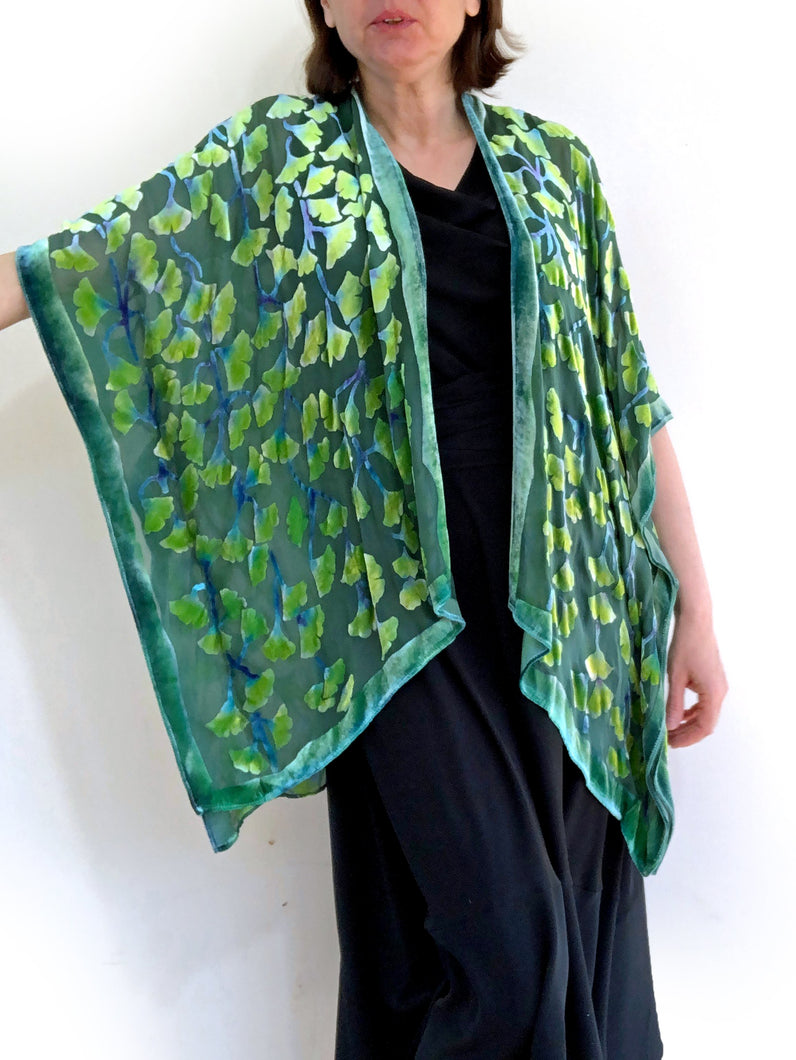 modeling green gingko leaf devoré or burnout velvet kimono jacket that is hand painted. Worn over back dress.